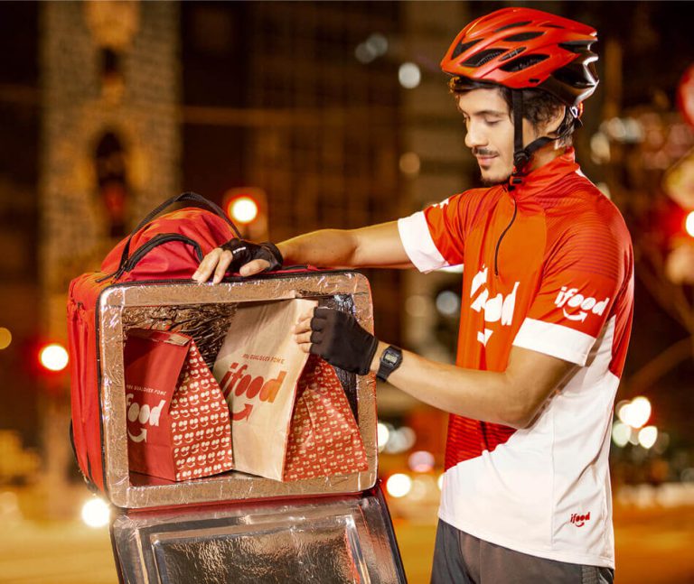 Entregador iFood arrumando os pedidos na bag