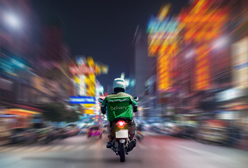 entregador andando de moto na rua de noite